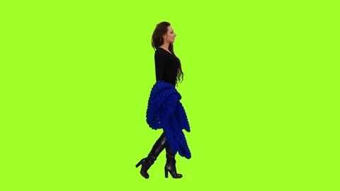 A young woman in black dress is walking on green screen background, Full HD shot Stock Footage