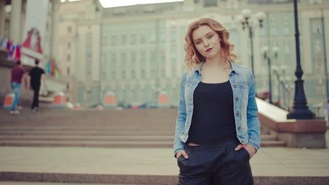 Young woman with blonde hair with blue jacket looking at camera and smiling Stock Footage