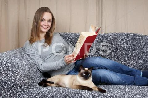 Young woman with book and cat Stock Photos