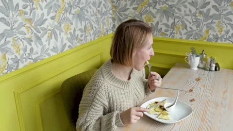Young woman for breakfast eats scrambled eggs. woman eating breakfast in a cafe Stock-Footage 139579585