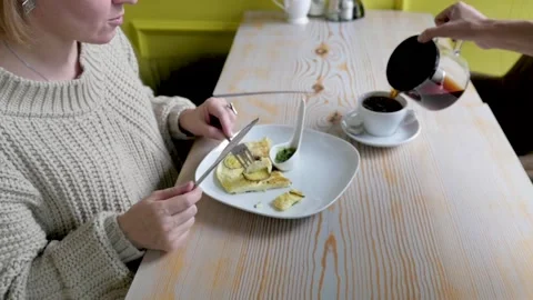 Young woman for breakfast eats scrambled eggs. woman eating breakfast in a cafe 스톡 동영상 139579676