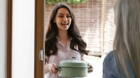 Young Woman Bringing Meal For Elderly Neighbour Stock Footage