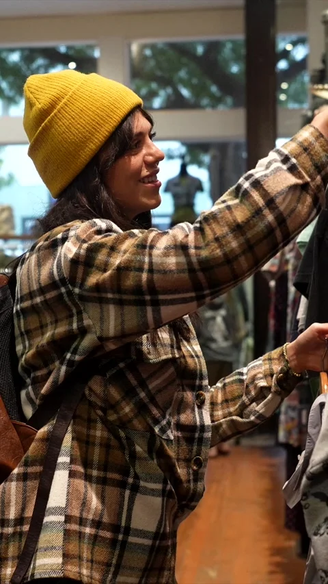 Young woman browsing clothes while shopping in a store Stock Footage 333106026