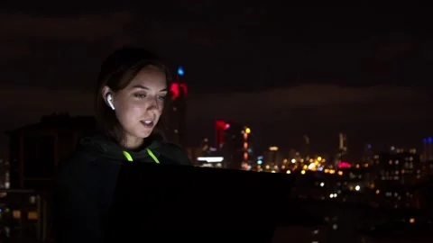 Young woman browsing laptop in night city Stock Footage