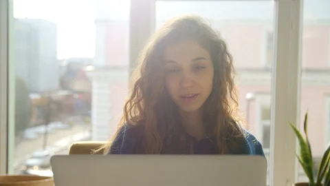 Young woman browsing the pc in front of the window Video stock 86589536