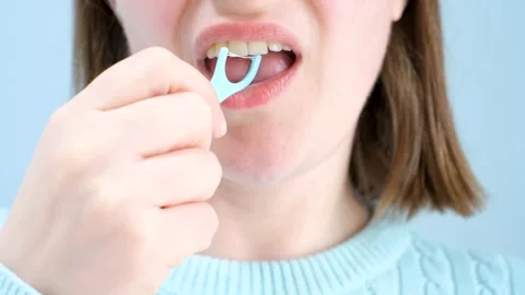 Young woman brushing teeth with disposable dental floss close-up front view on Stock Footage 306715565