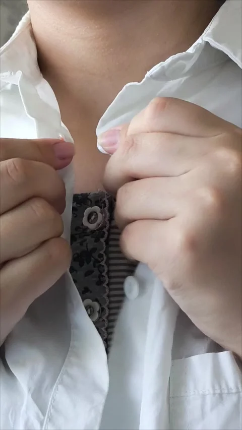 Young woman buttoning his white shirt at the neck Stockbeeldmateriaal 313184053