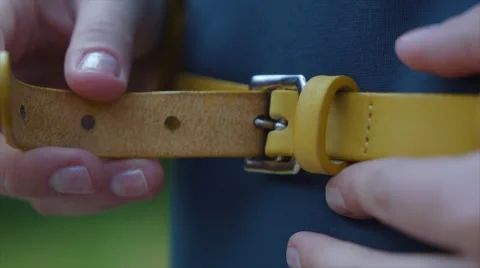 Young woman buttoning leather strap at the waist Stock Footage 63483311