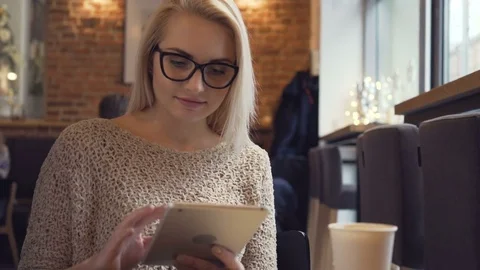 Young woman in cafe using her digital tablet Stock Footage 72045978