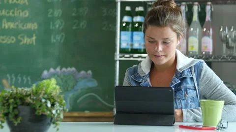 Young woman in a cafe using a laptop/touch screen Stock Footage 52327637