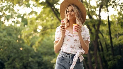 A young woman  cannot choose which to try first - ice cream or coffee Stock Footage 242597914