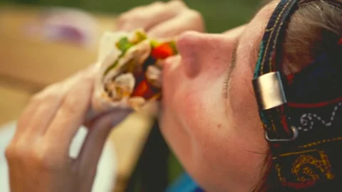 Young woman in cap eats kebab in pita bread, top view. Stock Footage 279395869