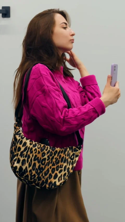 Young woman capturing stylish reflection. Fashion blogger with leopard bag 스톡 동영상 344728201
