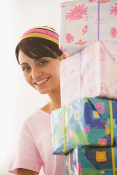 Young woman carrying stack of gifts Stock Photos