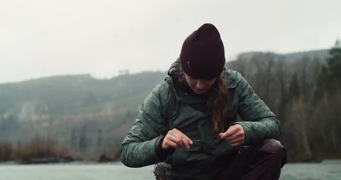 A young woman changes the lure on her Fly Fish Rod Stock Footage 102187853