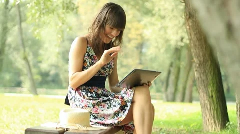 A young woman chatting on tablet computer, outdoors Stock Footage 8597771