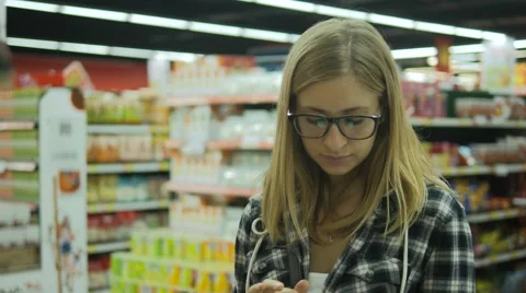 Young woman checking to do list on smartphone in grocery store with child Stock-Footage 65885979