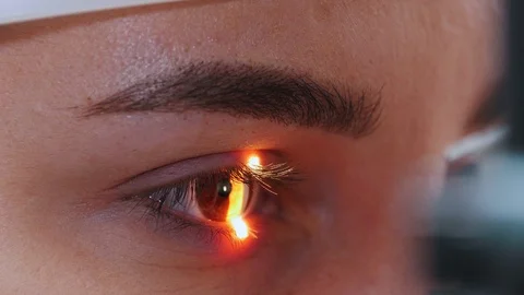 A young woman checking her visual acuity with a light of special big optometry Stock Footage 121128407