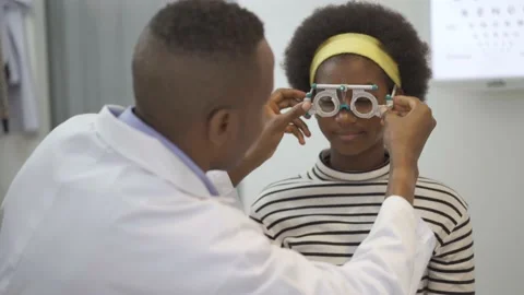 Young woman checking vision with eye test glasses during a medical examination Stock Footage 154399402