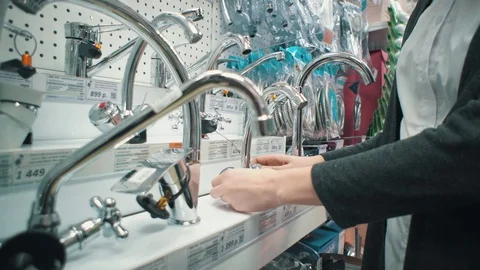 Young woman chooses mixer tap in self-service shop. Vídeos de archivo 106983653