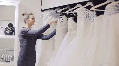 Young woman chooses wedding gown at bridal tore Stock Footage 59031112
