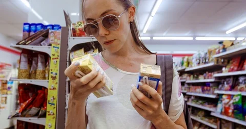 Young woman choosing between two boxes in shop Video stock 100219974