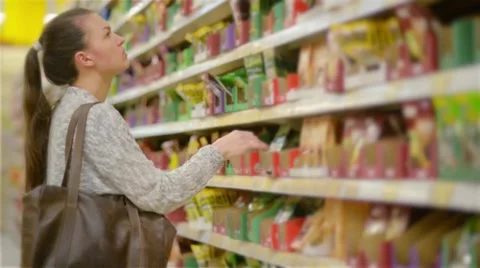 Young woman choosing spices in grocery store, beautiful woman shopping in a Stock Footage