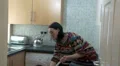 Young woman cleaning and talking on phone HD Footage