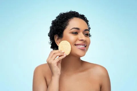 Young woman cleaning face with exfoliating sponge Stock Photos
