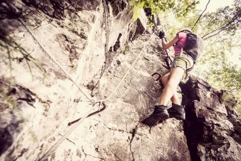 Young woman climbing on via ferrata Stock Photos