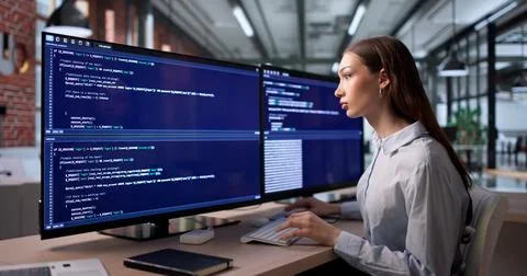 Young Woman Coder Typing Code At Desk Working On Software Project. Fotos Stock