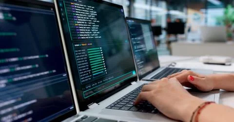 Young Woman Coding Securely On Laptop Using Cloud-based Programming Tools. Stock Photos