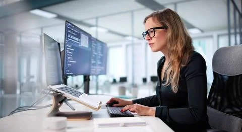 Young Woman Coding Website On Computer Screen In Office Environment. Stock Photos