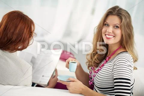 Young woman with coffee cup looking at camera and smiling Stock Photos