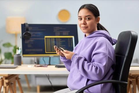 Young woman as computer programmer looking at camera at workplace 写真素材