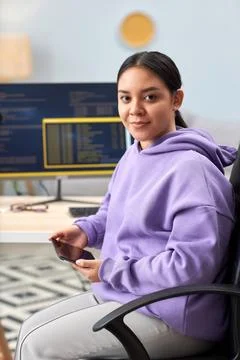 Young woman as computer programmer looking at camera at home office workplace 写真素材
