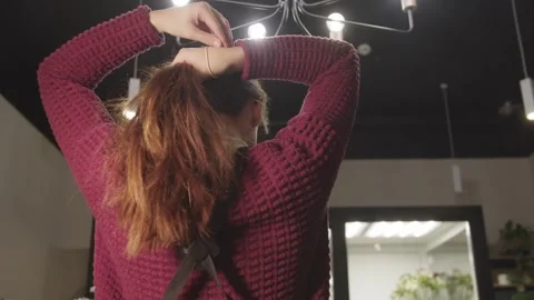 Young Woman Contemplating Her Reflection in a Flower Shop Mirror Stock Footage 255793029