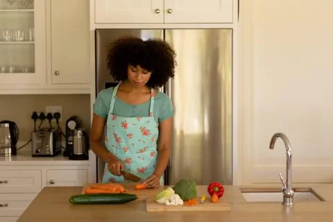Young woman cooking and wearing apron in the kitchen Stock Photos