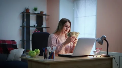 A young woman is counting dollars while sitting at a table, Stock Footage 155653000