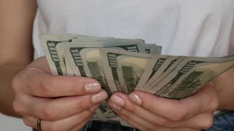 A young woman counting dollars while planning her finances. Stock Footage 306618085