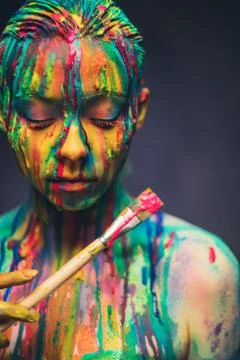 Young woman covered with a colourful paint Stock Photos