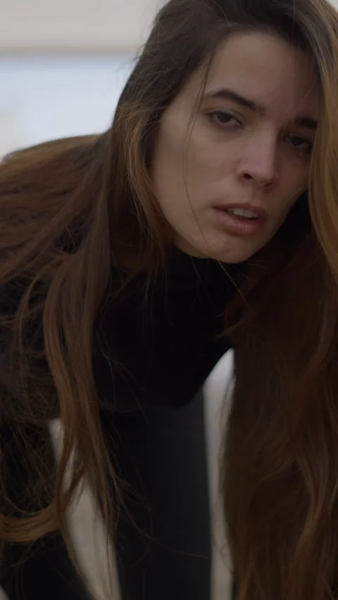 Young woman with crazy expression crawls closer and looks into camera Video stock 265957789