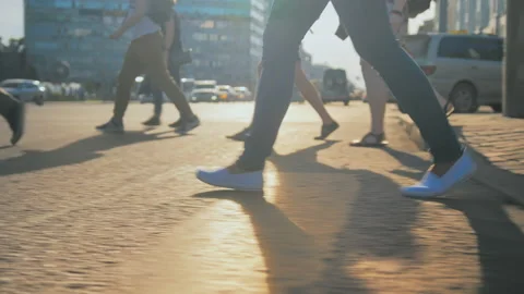 A young woman crosses the road on a sunny day. Legs of pedestrians crossing a Stock Footage