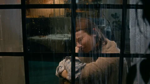 Young Woman Crying while Watching Thunderstorm and Rain from Window Stock Footage 303156114