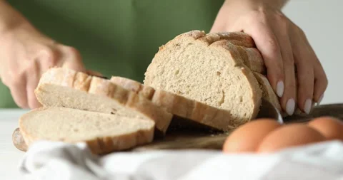 A young woman cuts bread in the kitchen. Stock Footage 250105436