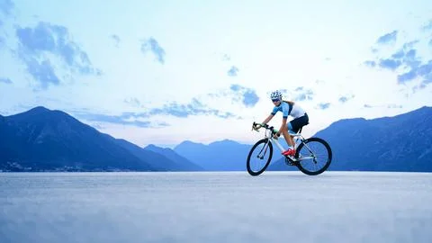 Young Woman Cyclist Riding Road Bike in the Beautiful Mountains. Adventure Stock Photos