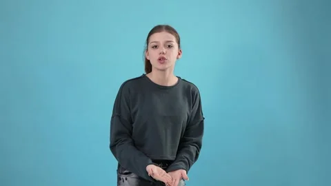 Young Woman Dancing and Gesturing on Blue Studio Background Stock Footage 344777364