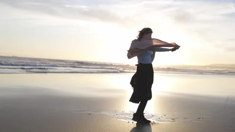 Young woman dancing on the beach at sunset Stock Footage 320056023