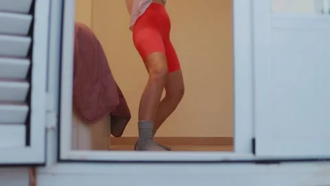 Young woman dancing dynamically, wearing red shorts and gray socks, visible.. 스톡 동영상 303662590