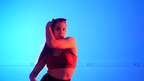 Young woman dancing modern dance on blue background, strip dance, vogue Stock Footage 107439341